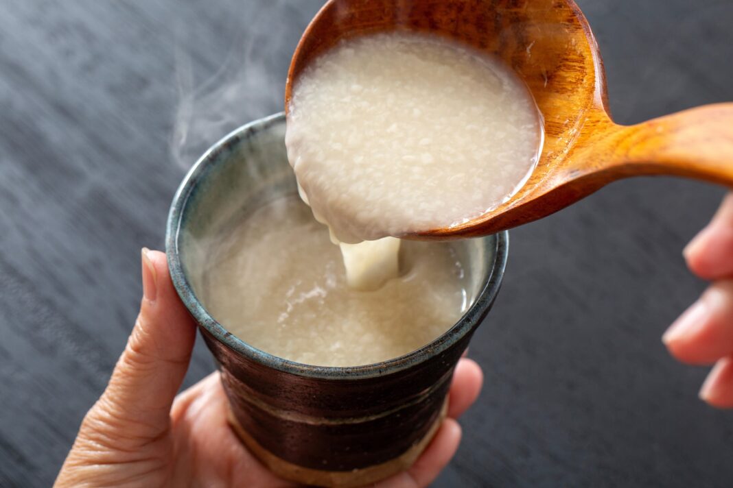 Vaso de amazake, bebida japonesa fermentada de color blanco cremoso, servido en una mesa.