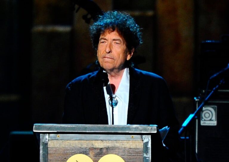 Bob Dylan en un escenario con guitarra acústica