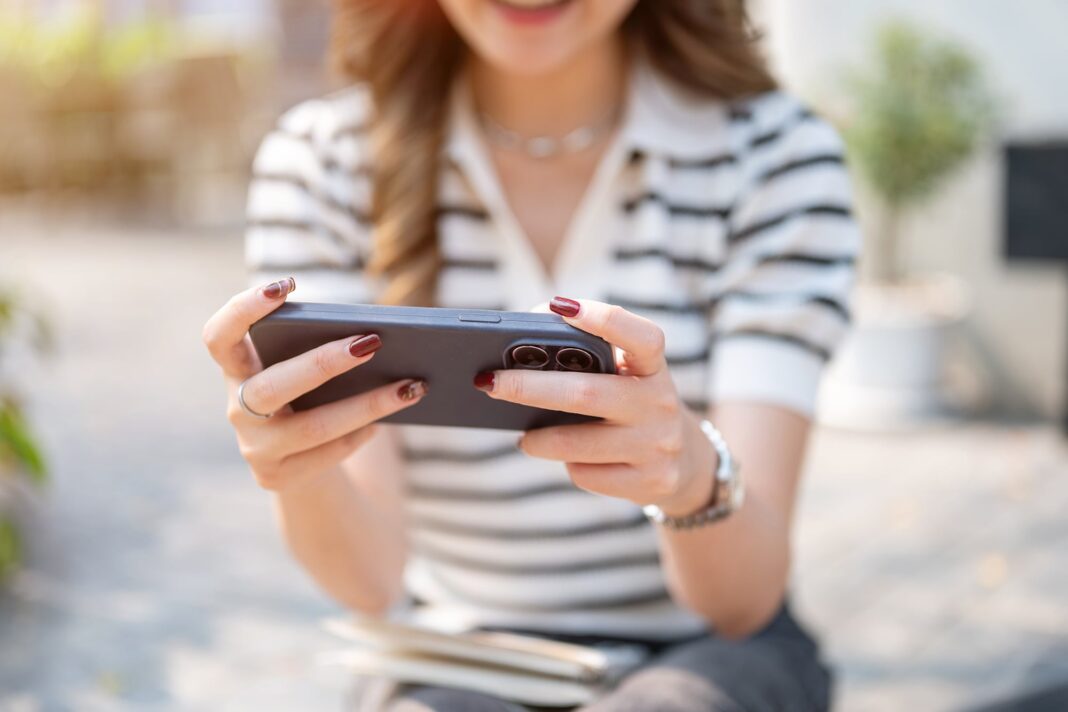 Persona usando un iPhone con Siri activado y el logo de ChatGPT en pantalla.