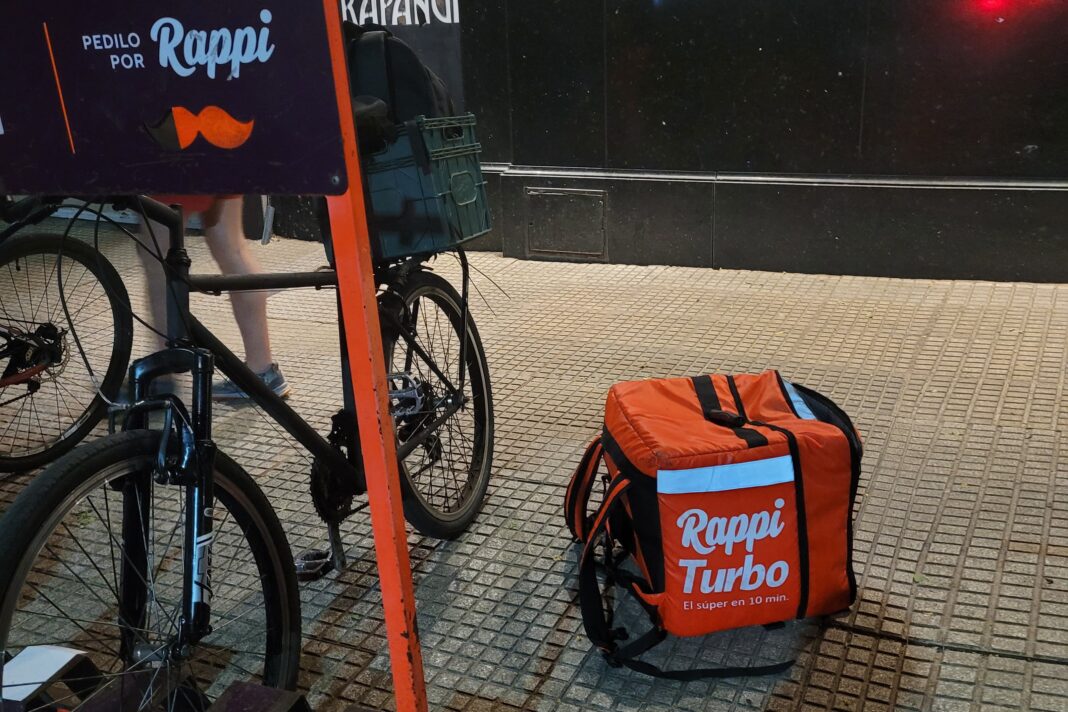 Repartidor de delivery con mochila térmica en una calle, representando el sector de las plataformas de reparto.
