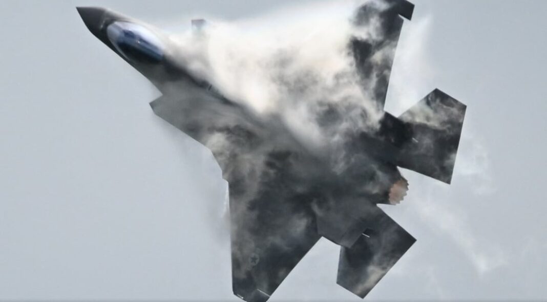 Ilustración de un caza F-15E en vuelo sobre un paisaje desértico.