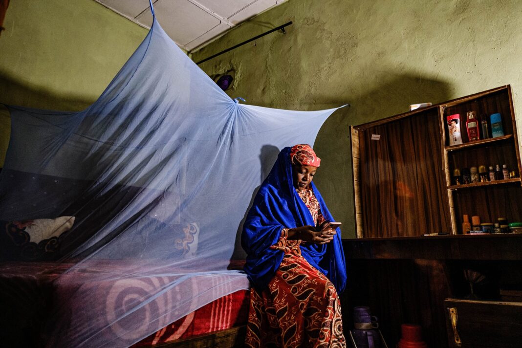 Ilustración de un teléfono móvil mostrando un grupo de WhatsApp con portadas de novelas románticas o eróticas.