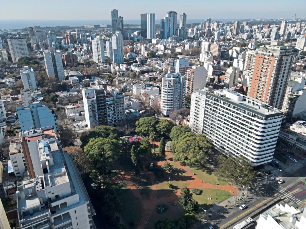Persona revisando una liquidación de expensas y calculadora sobre una mesa.