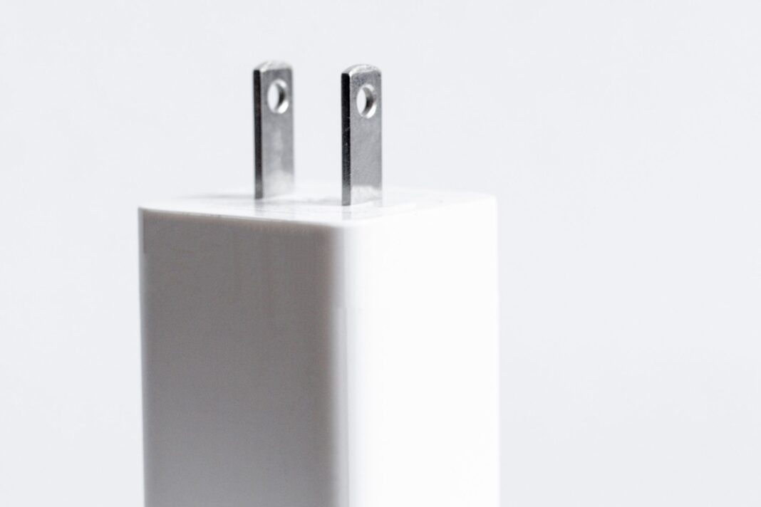 Primer plano de un enchufe tipo A con dos agujeros visibles en sus patas metálicas