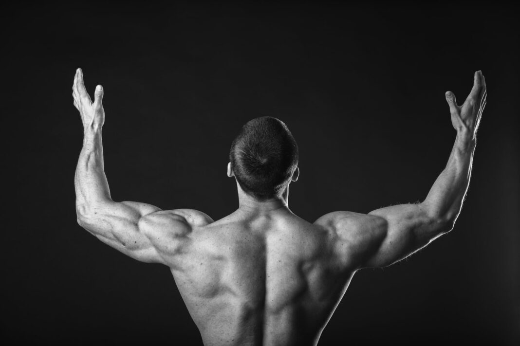 Mujer utilizando una plataforma vibratoria durante una sesión de ejercicio en su casa.