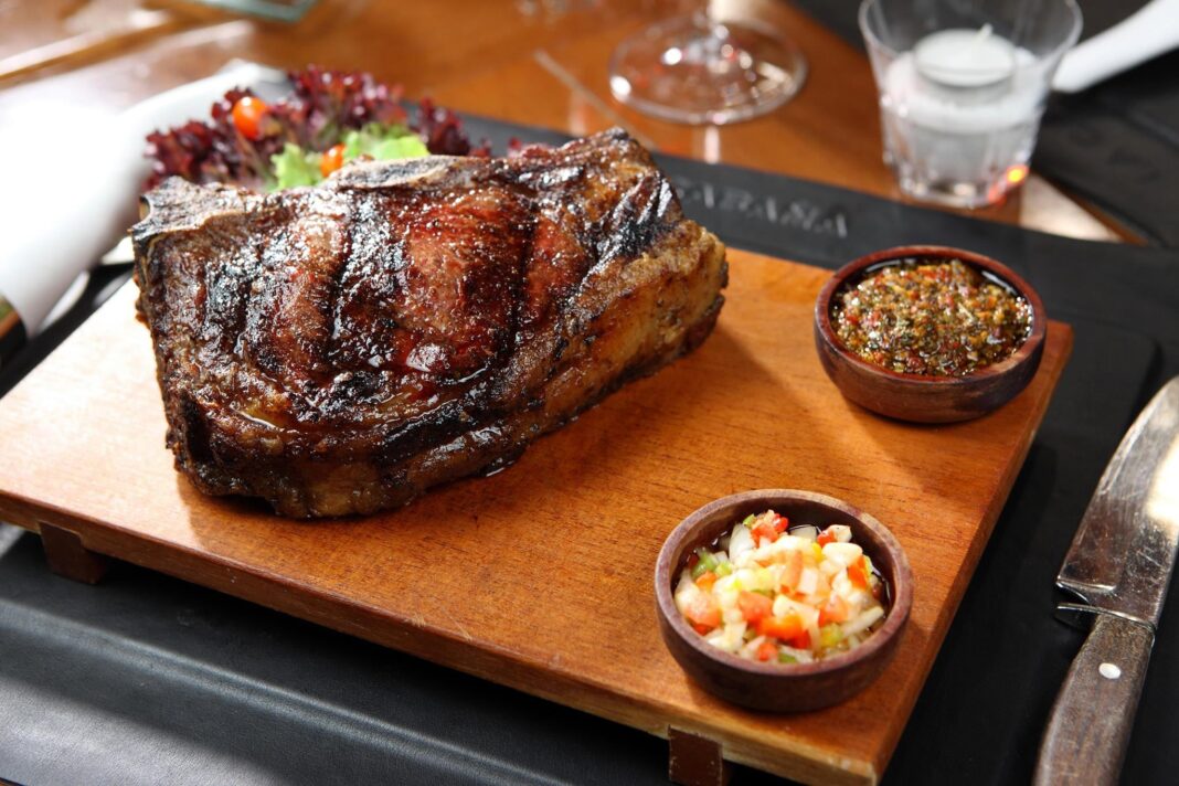 Mapa mundial con ubicaciones de restaurantes argentinos y precios referenciales de bife de chorizo y vino Malbec.