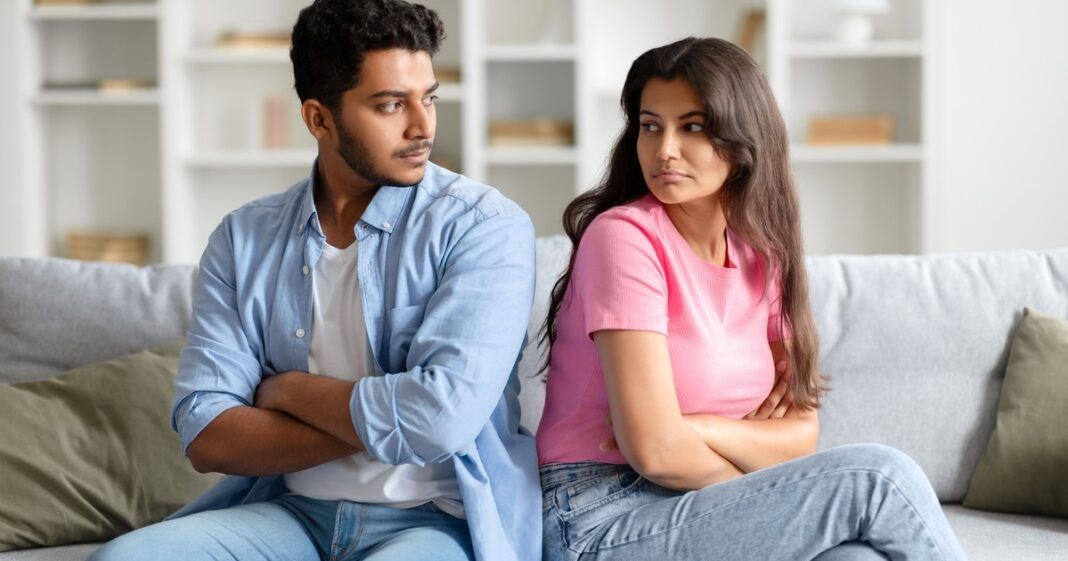 Ilustración de una pareja sentada en un sofá, cada uno con un celular, en un ambiente doméstico.