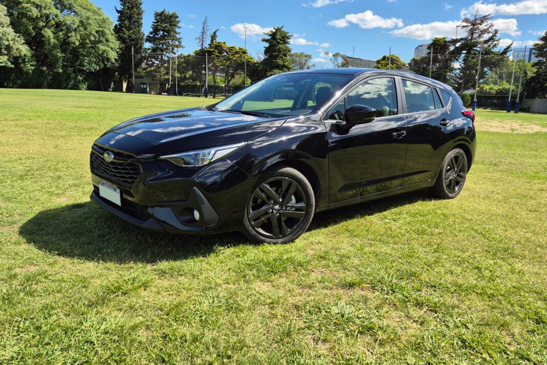 Subaru Impreza 2025 hatchback de color gris, vista lateral en movimiento.