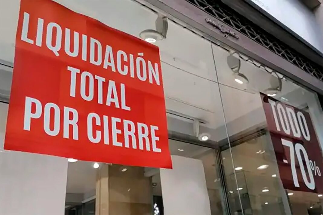 Comerciante atendiendo en un local comercial con cartel de liquidación