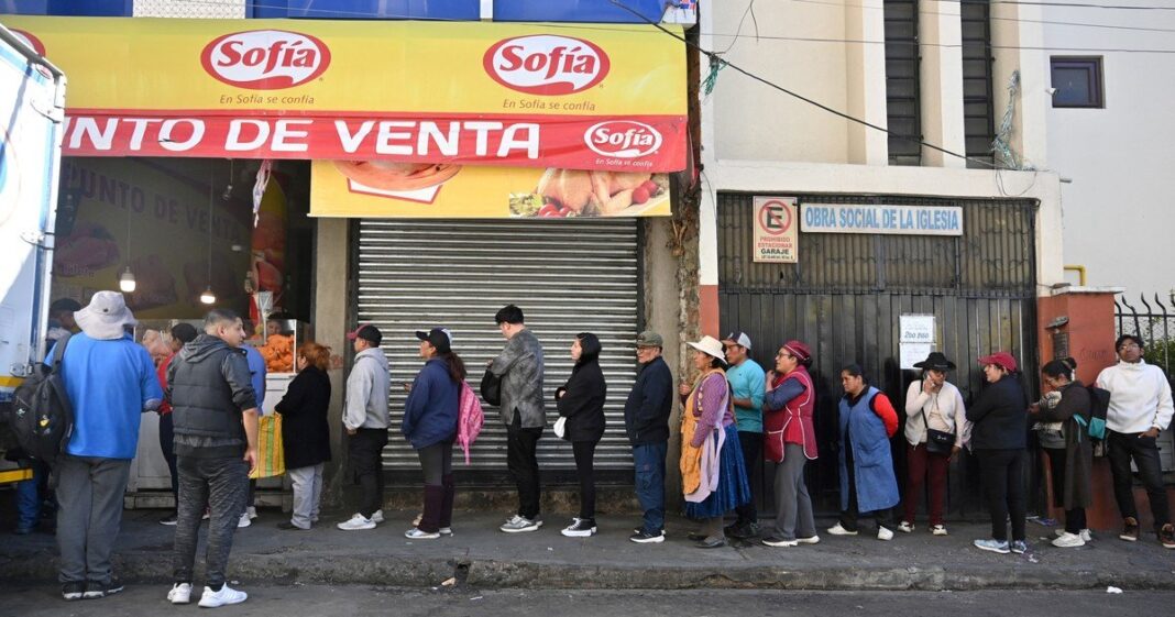 Personas hacen fila para comprar alimentos en un mercado de La Paz durante bloqueos