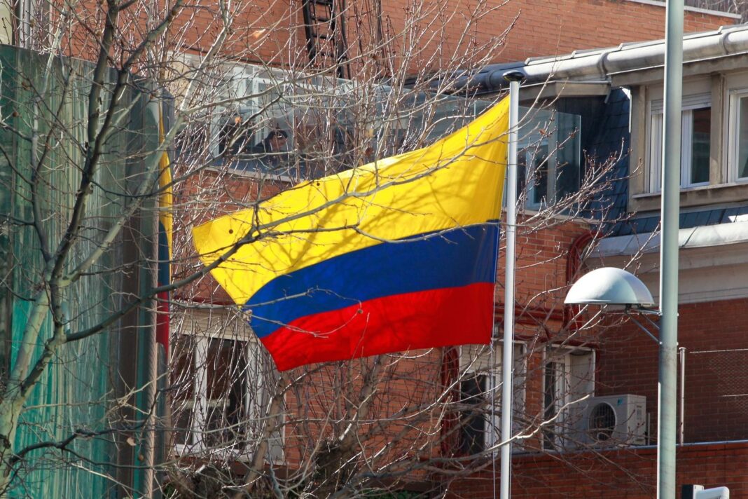 Urna electoral con bandera de Colombia y tarjetas de votación