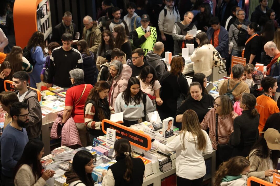 Pasillo de la Feria del Libro con visitantes y stands