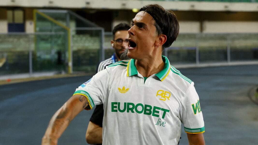 Paulo Dybala celebrando en el campo de juego con el escudo de la Champions League