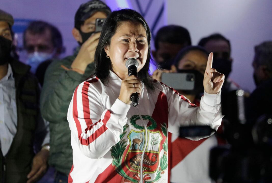 Urnas y banderas de Perú en un centro de votación durante las elecciones presidenciales de 2025