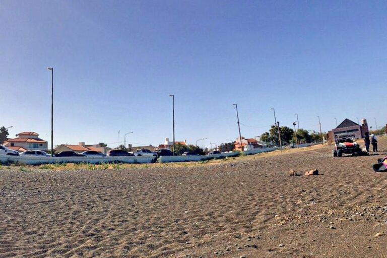 Vista de Playa Unión en Rawson, Chubut, con surfistas y familias en la costa patagónica