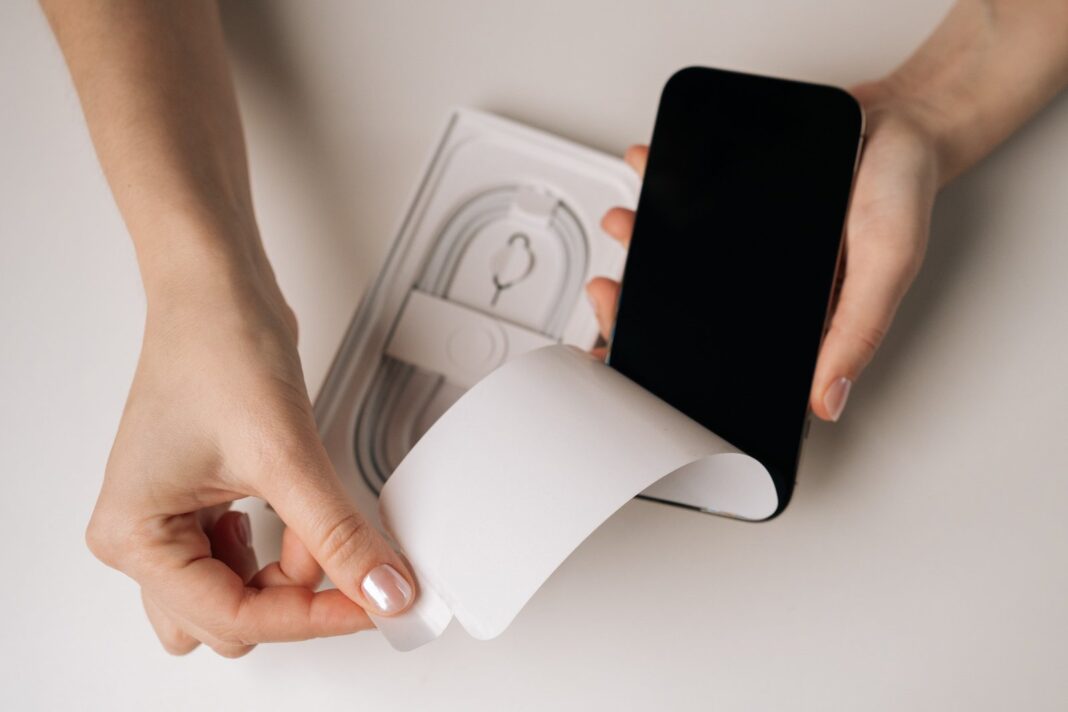 Persona revisando un teléfono celular en su caja original