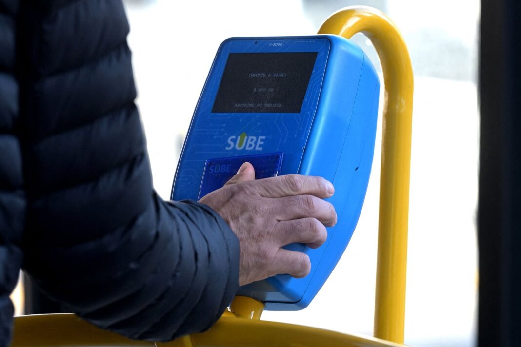Tarjeta SUBE sobre un fondo de colectivo y tren