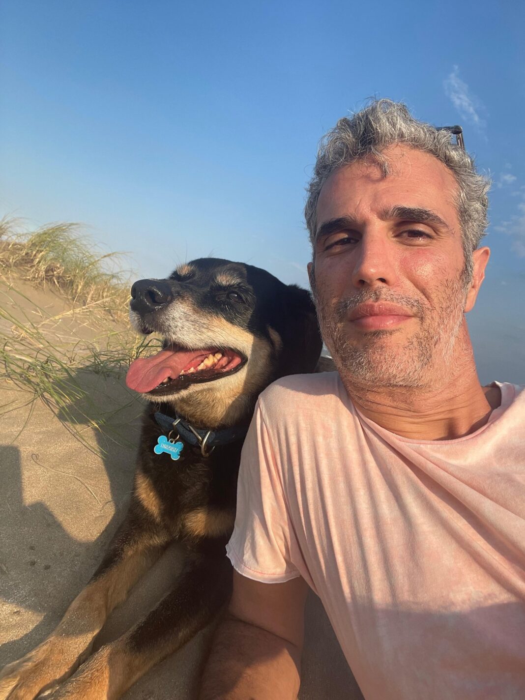 Perro Cacho sentado junto a su dueño Patricio Witis en una plaza