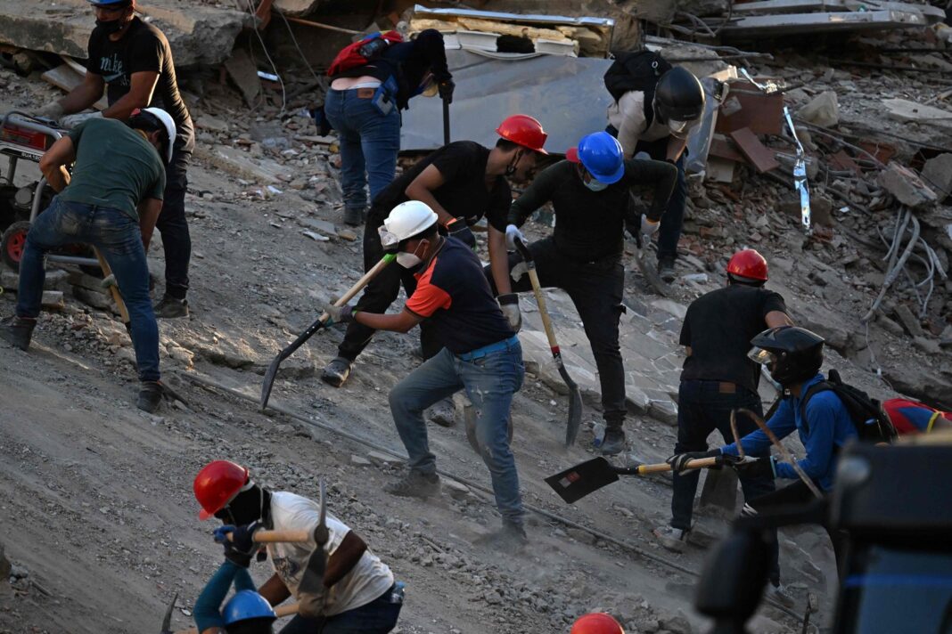 Voluntarios removiendo escombros con pico y pala en La Guaira tras terremoto en Venezuela