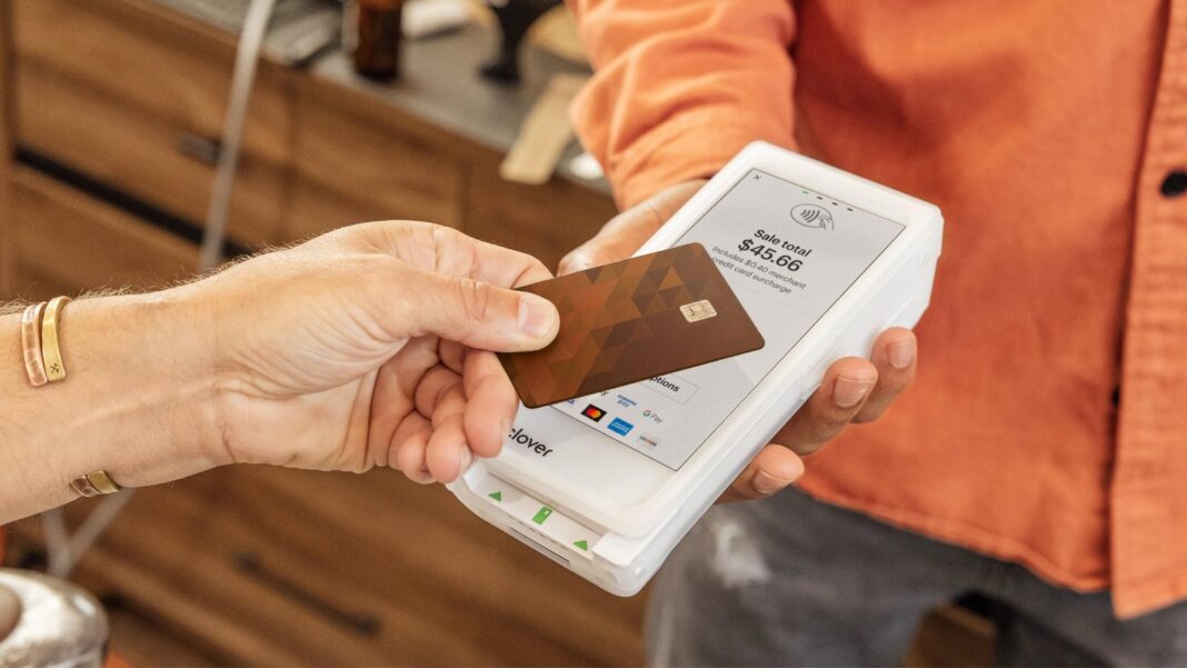 Persona usando un teléfono móvil para realizar un pago digital en un comercio