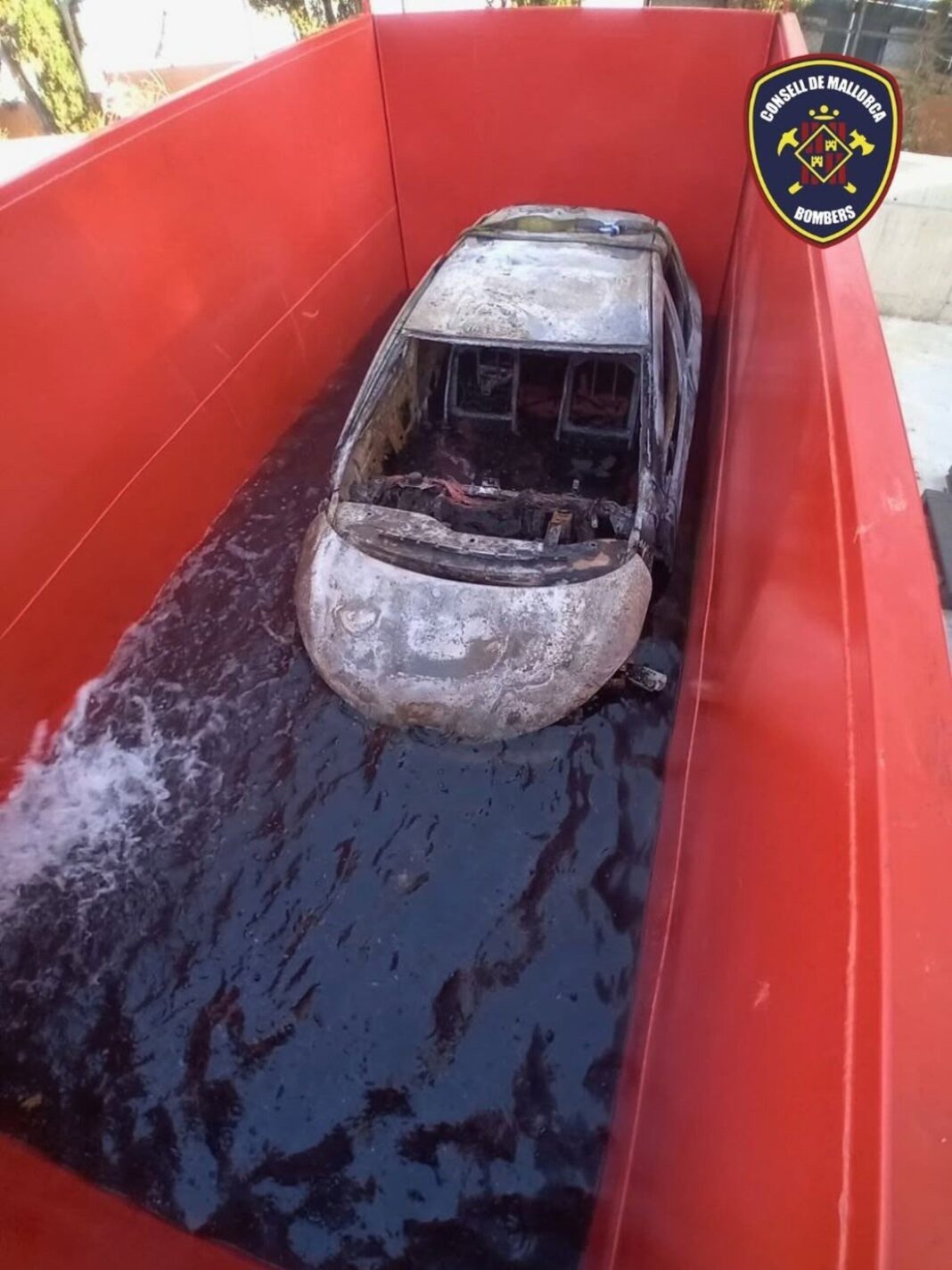 Bomberos introduciendo un vehículo incendiado en un depósito de agua en Betlem