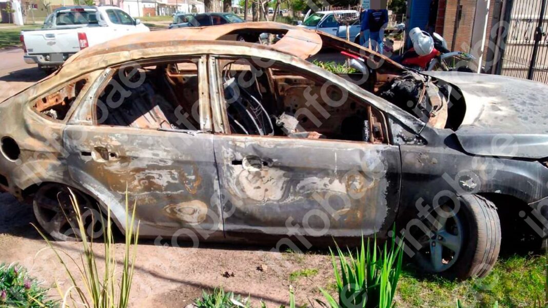 Ford Focus incendiado en la vía pública, con daños visibles en la carrocería y el interior