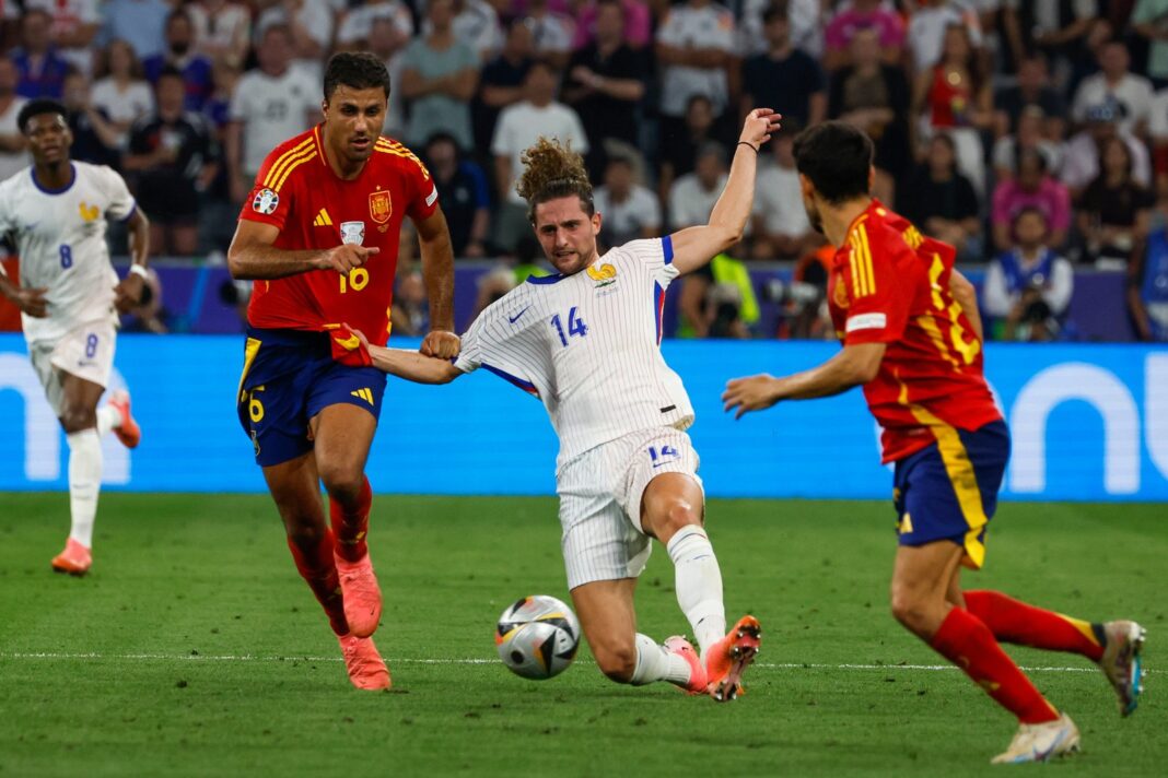 Jugadores de España y Francia disputando el balón en un partido de fútbol