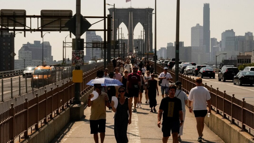 Persona usando un ventilador en un día de calor extremo en Estados Unidos
