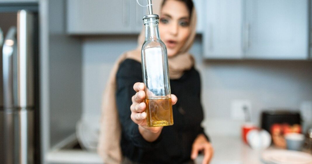 Elena Díaz catando aceite de oliva en una copa de vidrio azul