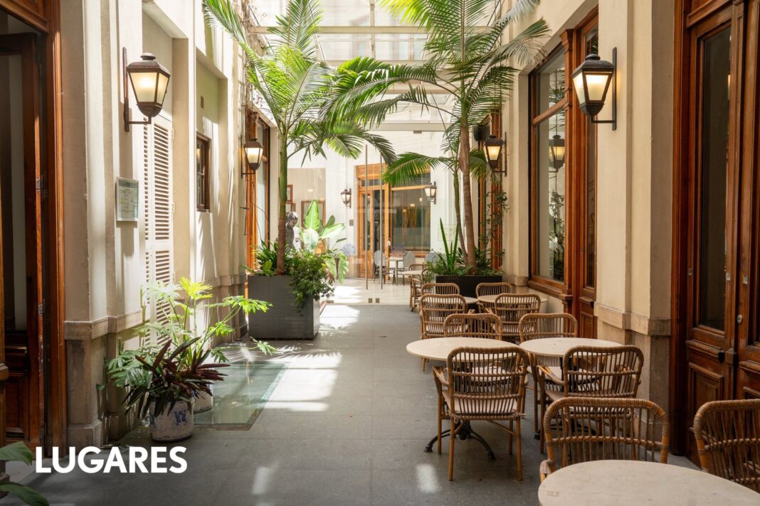 Salón histórico del Hotel Palladio Buenos Aires con paneles de madera y escultura de bronce