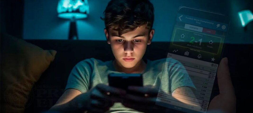 Adolescente usando un teléfono móvil, representando las apuestas online