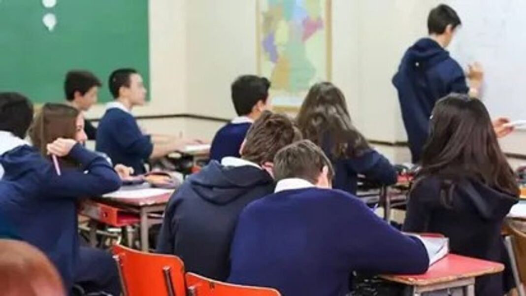 Aula escolar vacía con bancos y pizarra, representando la mora escolar en Tucumán