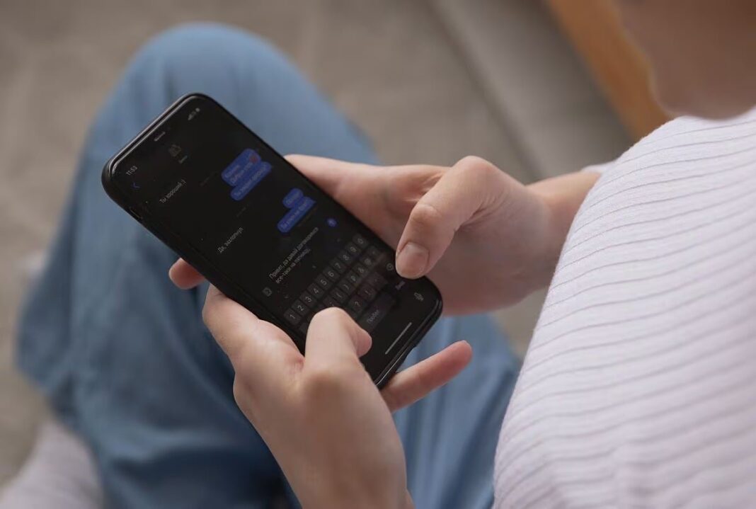 Persona escribiendo un mensaje de texto en su teléfono móvil